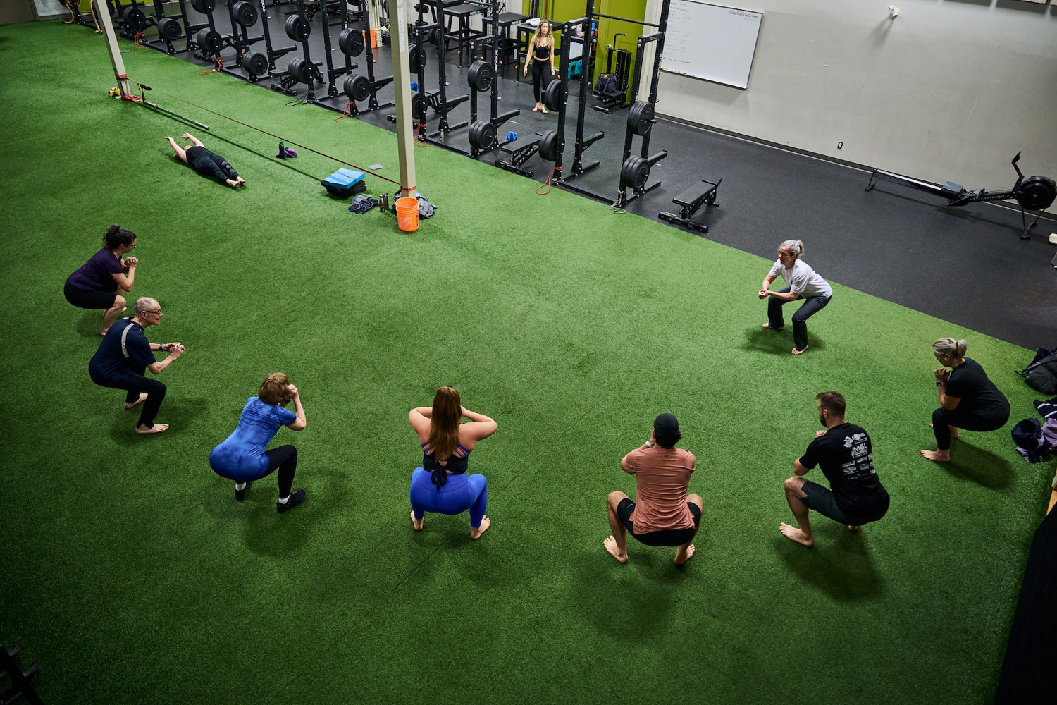 Group fitness members squatting at a Group Fitness Class at Human 2.0 Ottawa Physiotherapy, Massage, & Gym South Keys Location