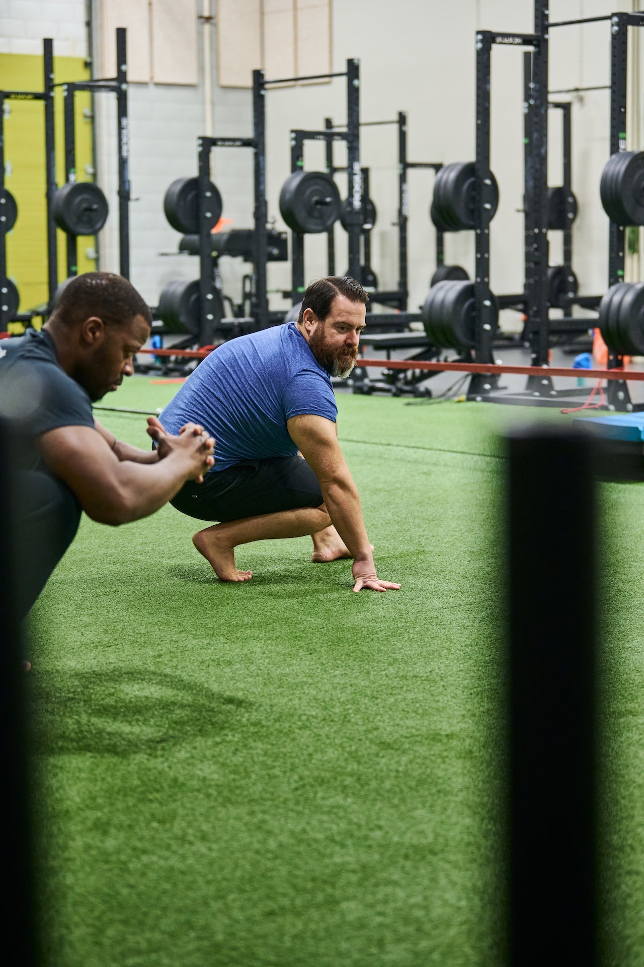 Human 2.0 group fitness class members perform a bodyweight squat during a group fitness class at Group fitness members at Human 2.0 Ottawa Physiotherapy, Massage, & Gym South Keys Location