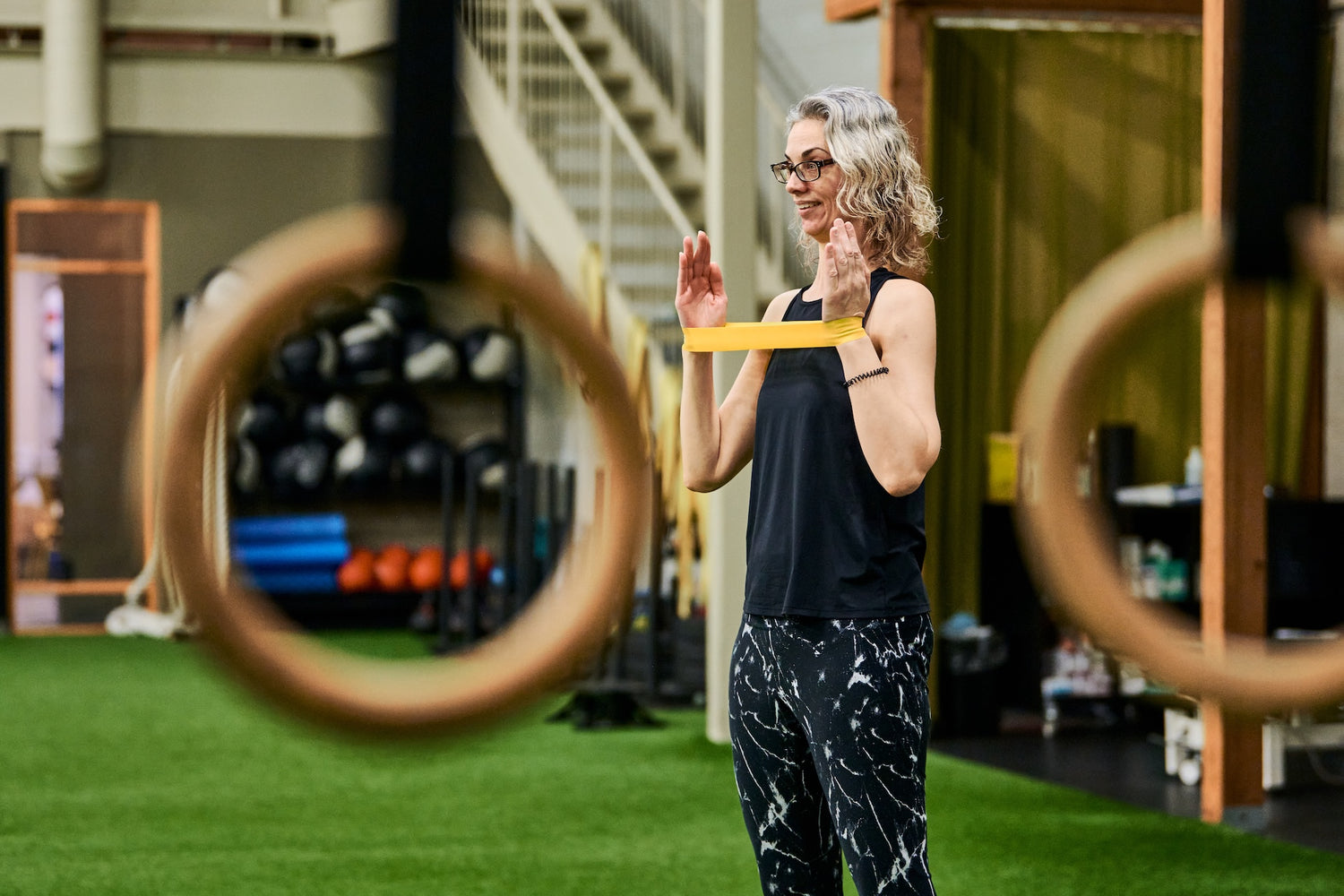 Group fitness member warming up shoulders with a resistance band during a Group Fitness Class at Human 2.0 Ottawa Physiotherapy, Massage, & Gym South Keys Location