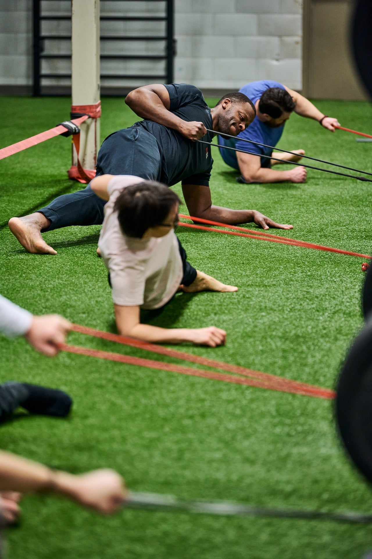 Group fitness members perform core strengthening exercise using resistance bands during a group fitness class at Human 2.0 Ottawa Physiotherapy, Massage, & Gym South Keys Location