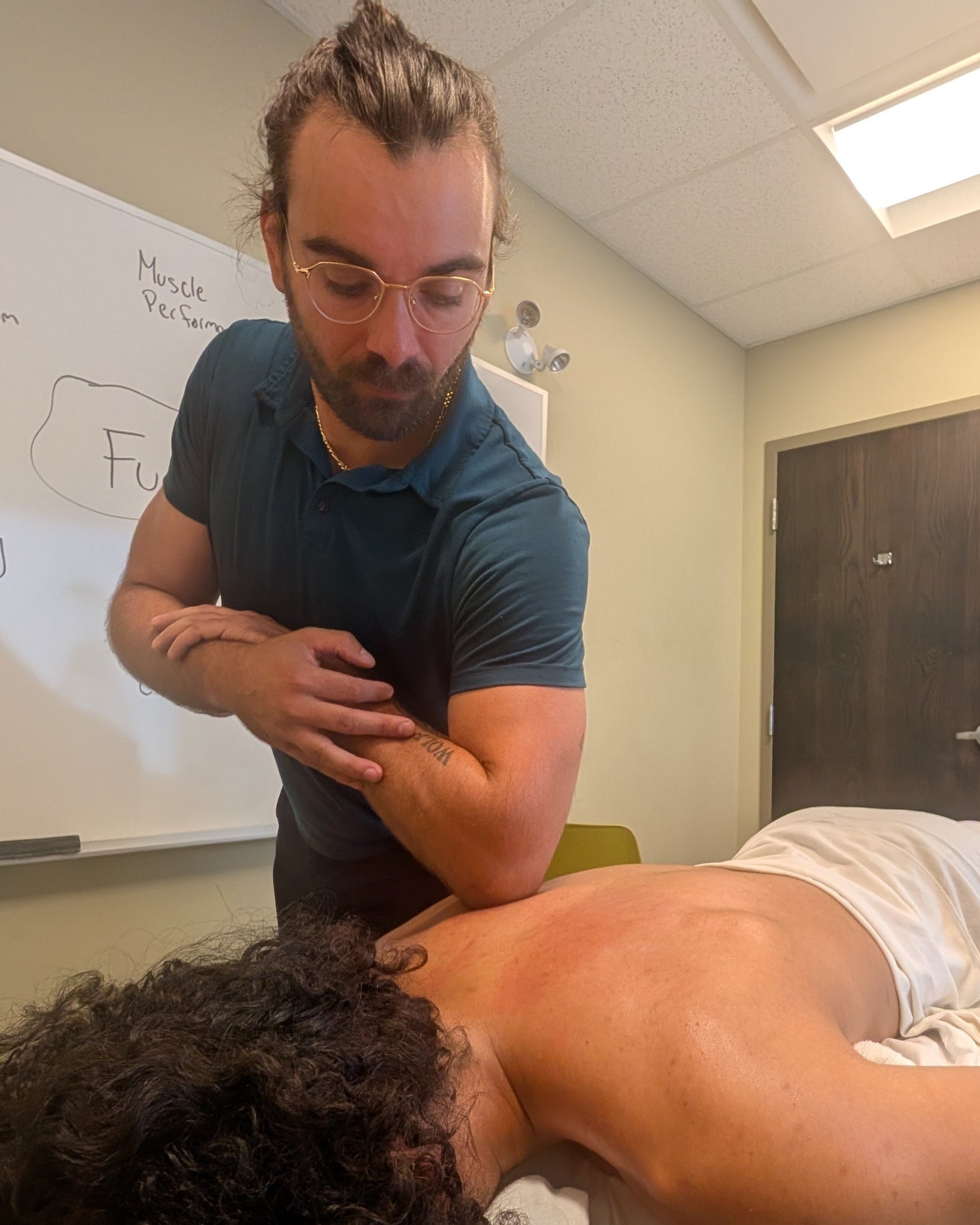 Ottawa-based massage therapist Keith Micomonaco performing a massage technique on a massage client massage therapist at Human 2.0 Ottawa Physiotherapy, Massage, & Gym South Keys Location