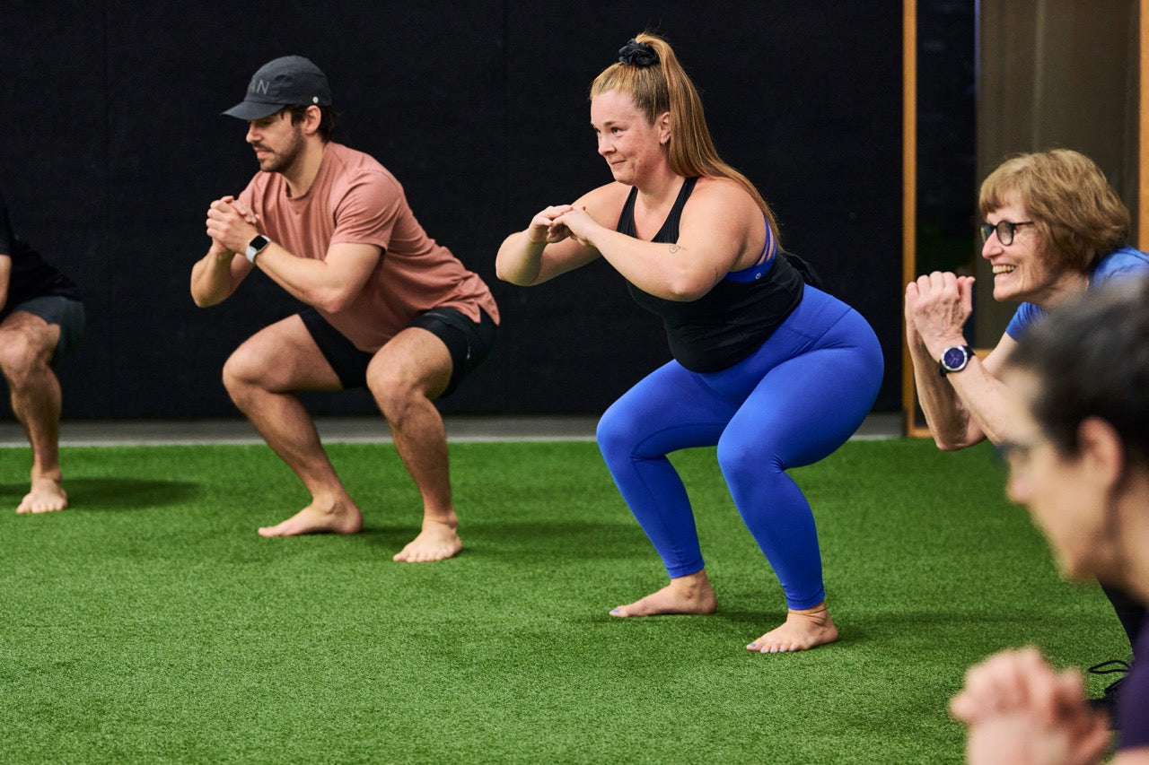 Human 2.0 group fitness class performing squats